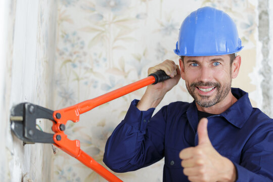 male builder using bolt cropper with thumbs-up