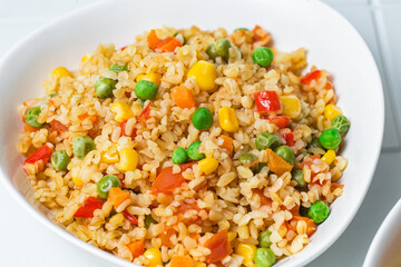 Bulgur with vegetables in a white plate close-up