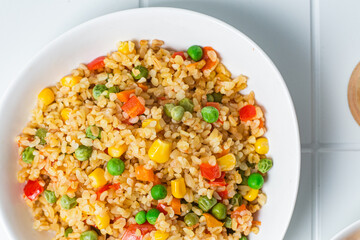 Bulgur with vegetables in a white plate close-up
