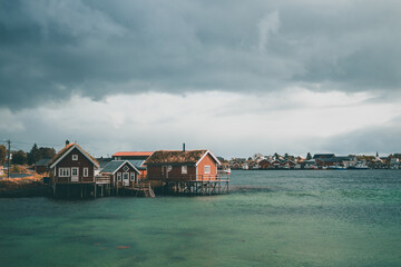 Obraz premium Typical red wooden houses at the harbor, on the Lofoten Islands in Norway - during an beautiful autumn day