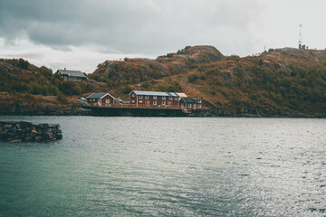 Fototapeta premium Typical red wooden houses at the harbor, on the Lofoten Islands in Norway - during an beautiful autumn day