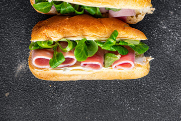sandwich ham french milk buns, cheese, lettuce green leaves fresh meal food snack on the table copy space food background rustic top view