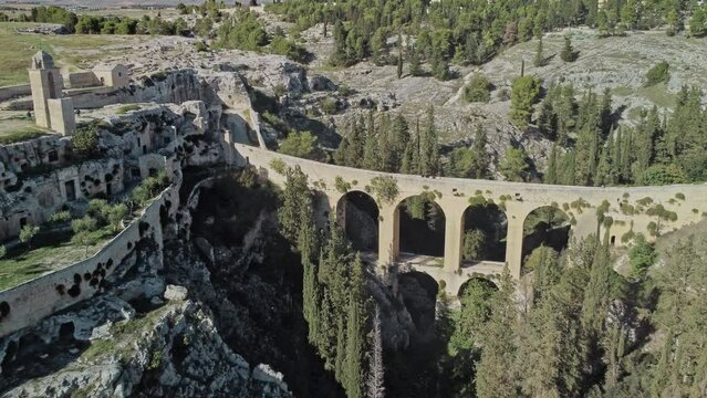 Canyon of Gravina with the old aqueduct stone bridge. Apulia region, Italy