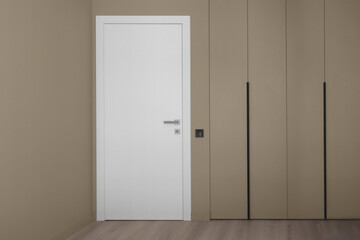 White door on the background of an empty wall
