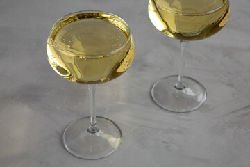 Sparkling Champagne in a Coupe Glass on a gray background, side view.