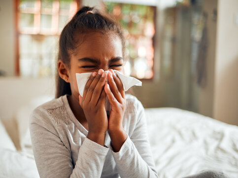 Health, covid and sick black girl blowing nose in home bedroom. Wellness, healthcare and kid with tissue to wipe for virus, infection or cold, flu or fever, allergy or corona illness in house alone.