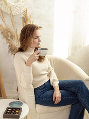 Woman drinks tea or coffee with sweets. Natural