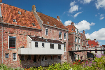 Summer view of Dutch medieval houses with hanging kitches at the Damsterdiep canal in Appingedam,...