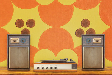 Record player with two vintage stereo speakers in front of retro seventies flower wallpaper