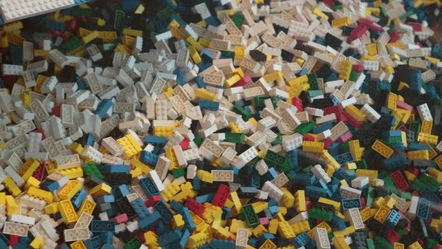 Many colorful pieces of plastic constructor, disassembled building blocks in close up. Concept of modern Art, collecting. Toys for kids, children's leisure