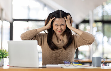 Tired Young freelance asian business woman with headache at office, feeling sick at work, Sad, unhappy, Worried, Depression, or employee life stress concept.