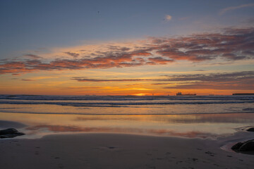 Fototapeta na wymiar Sunset on the beach with peace of orange colors and blue sea