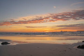 Obraz premium Sunset on the beach with peace of orange colors and blue sea