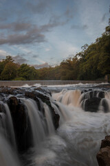 Fototapeta na wymiar Waterfall in the river flow, Strong water flow between stone rocks