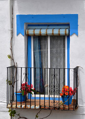 Fototapeta na wymiar balcony in white and blue facade with flowers