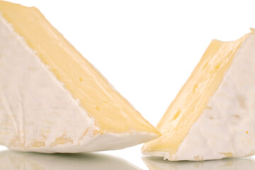 Two pieces of fragrant brie cheese, macro, isolated on white background.