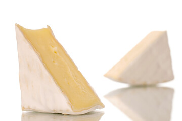 Two pieces of fragrant brie cheese, macro, isolated on white background.
