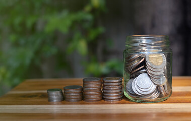 money saving concept, stacking coin on wooden table and natural background