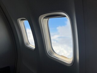 Duas janelas de avião com o céu ao fundo