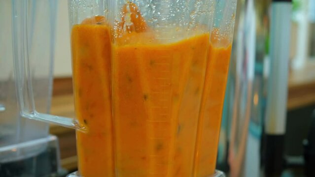 blender grinds sea buckthorn. Mango fresh in a blender. A sea buckthorn, orange drink is whipped in a blender
