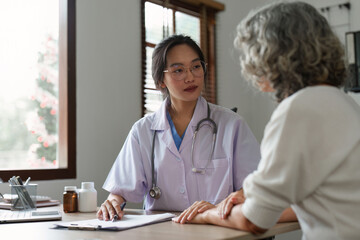 Doctor talking with elderly asian woman. Female primary care physician having conversation with older woman. Elderly Healthcare