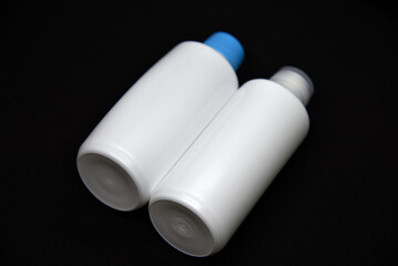 Plastic white vials on a black background. Plastic bottles. White plastic containers.