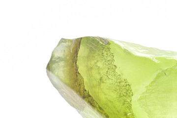 Macro focused raw shiny semi-transparent light lime green, pistachio calcite stone, light green carbonate crystal isolated on a white surface background