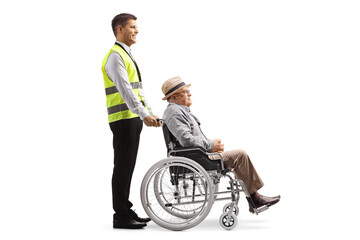 Full length profile shot of a guard standing with a mature man in a wheelchair