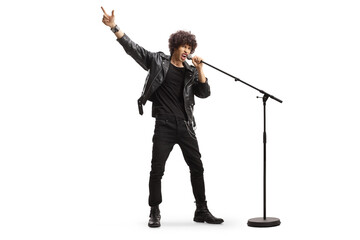 Man in a leather jacket singing on a microphone and pointing up