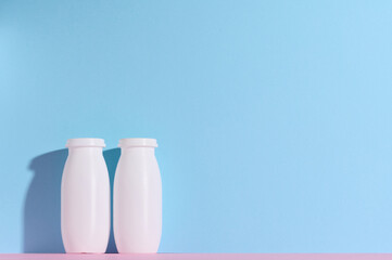 White plastic bottles for yogurt and dairy products on a blue background