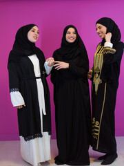 Group portrait of beautiful muslim women two of them in fashionable dress with hijab isolated on...