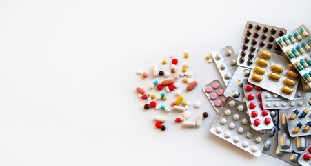 Fototapeta na wymiar Blisters with various pills and capsules on a white background with copy space. Medicine, pharmaceuticals, treatment and prevention of diseases.