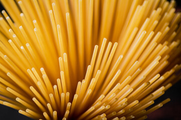 Not boiled spaghetti dry on a black background.