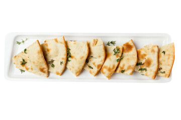 Pieces of focaccia with herbs on a white plate. Appetizing traditional Italian bread. Top view. Isolated on white background.