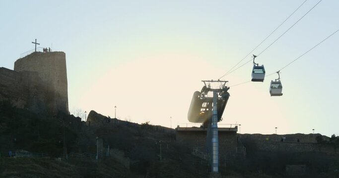 Georgia, Tbilisi. The cabins of the feniculaire move along the cable car between the city center of Tbilisi and the Narikala fortress on the Sololaki hill against the backdrop of the evening sky
