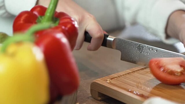 Donna taglia un pomodoro in cucina