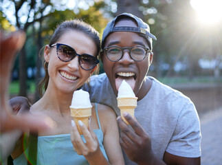 Love, ice cream or couple take a selfie in a park on a romantic date in nature in an interracial marriage. Pictures, black man or happy woman eating or enjoying a snack on holiday vacation