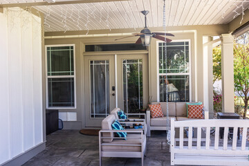 Covered outdoor patio in a new construction house home with guest seating