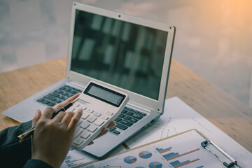 Business woman accountant, office worker working on desk, hand pressing calculator to calculate business profit and loss, calculating budget, income. Expense of credit card for payment on table.