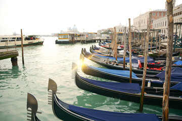 Fototapeta na wymiar Grand Canal in the morning.Gondolas tied to wooden poles in Venice, Italy. Beautiful romantic italian city.