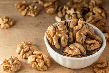 bowl of Shelled walnut wooden table healthy food Close-up  kernels and whole walnuts on rustic old.