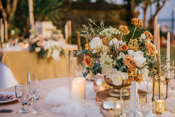 Beautiful table setting with tableware, flowers, candles, accessories and rose centerpiece for a party, wedding reception, gala banquet or other holiday event. - obrazy, fototapety, plakaty