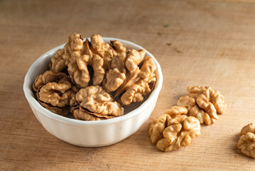 bowl of Shelled walnut wooden table healthy food Close-up  kernels and whole walnuts on rustic old.