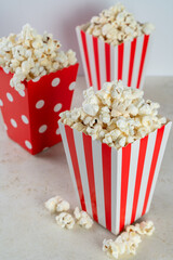 Three bags of popcorn in red and white on a white background, front view, closeup