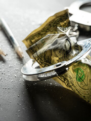 Handcuffs, dollar bills and drug powder	