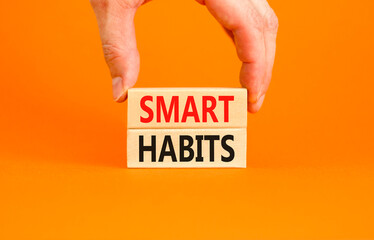 Smart habits symbol. Concept words Smart habits on wooden blocks. Beautiful orange table orange background. Businessman hand. Business and smart habits concept. Copy space.