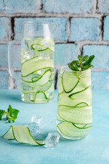 Fresh infused cucumber water on a light blue background