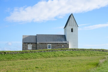 Fototapeta na wymiar Beautiful church that sits on the top of a steep sandy cliff