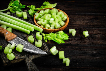 Sliced fresh celery. On a dark wooden background.