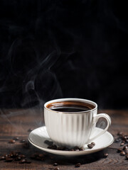 cup of hot coffee on a wooden table, black background